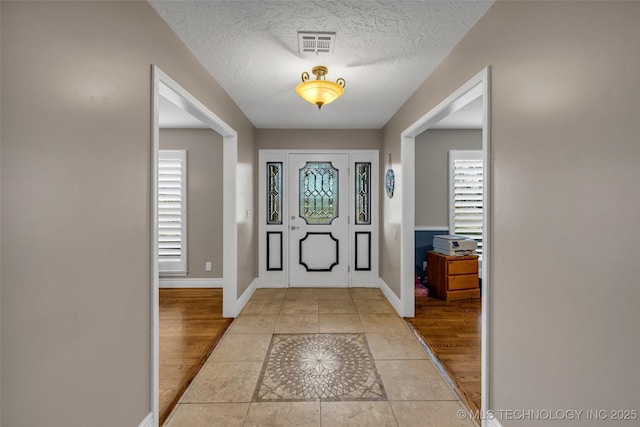 tiled foyer entrance featuring a textured ceiling