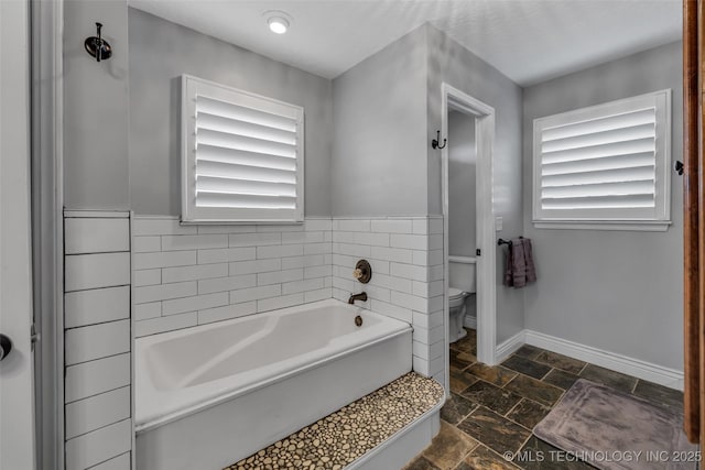 bathroom featuring toilet and a tub