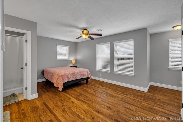 bedroom featuring ceiling fan, dark wood-type flooring, and a textured ceiling