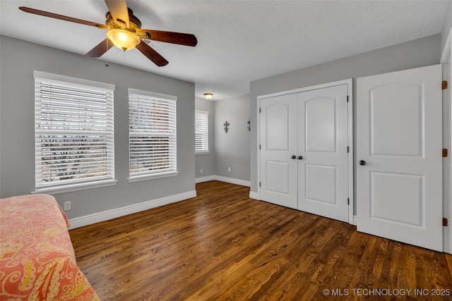 bedroom featuring ceiling fan, dark hardwood / wood-style floors, and a closet