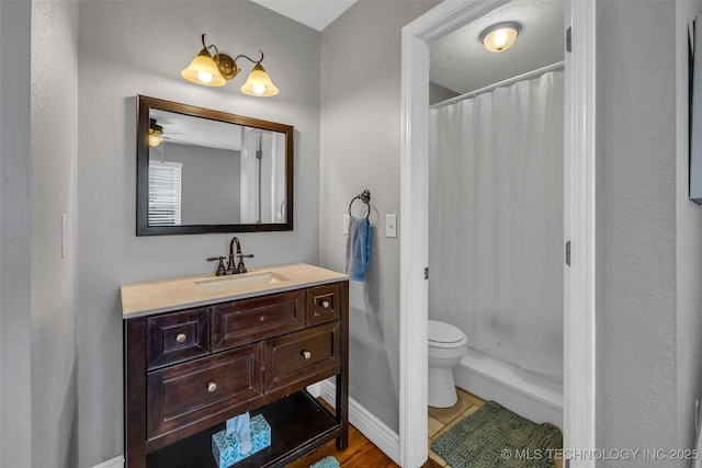 bathroom featuring vanity, a shower with curtain, ceiling fan, toilet, and a textured ceiling