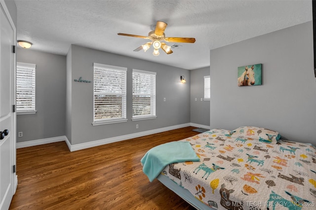 bedroom with ceiling fan, a textured ceiling, and hardwood / wood-style flooring