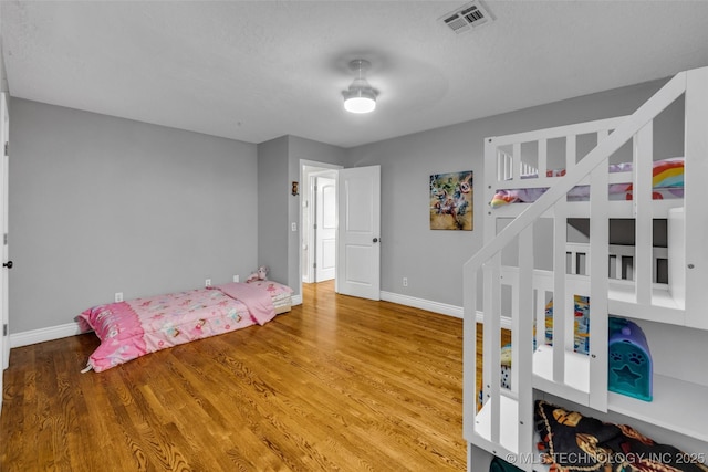 bedroom with hardwood / wood-style floors and a textured ceiling