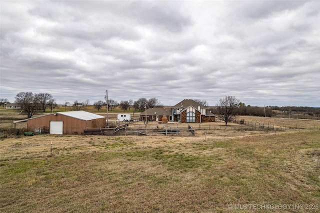 view of yard with a rural view and an outdoor structure