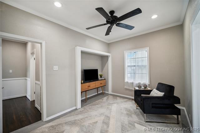 sitting room with hardwood / wood-style flooring, ceiling fan, and ornamental molding