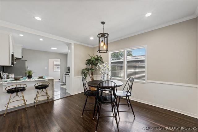 dining area with dark hardwood / wood-style floors and ornamental molding