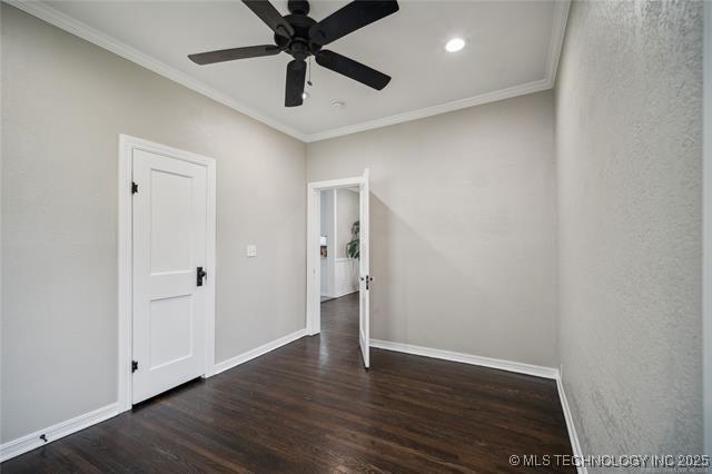 empty room featuring ceiling fan, dark hardwood / wood-style floors, and ornamental molding