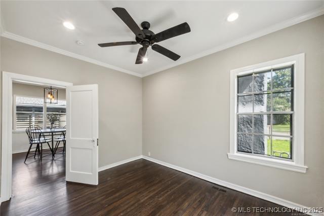 spare room featuring a wealth of natural light, dark hardwood / wood-style flooring, ceiling fan, and ornamental molding