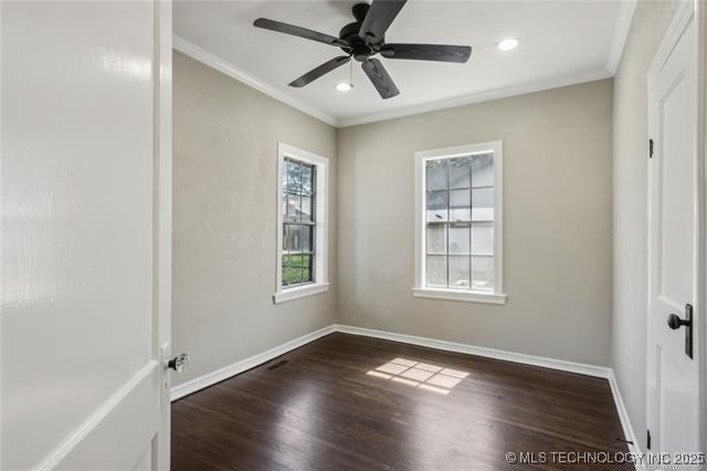 empty room featuring dark hardwood / wood-style flooring, ceiling fan, and crown molding