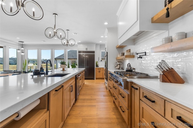 kitchen with white cabinetry, appliances with stainless steel finishes, open shelves, and a sink