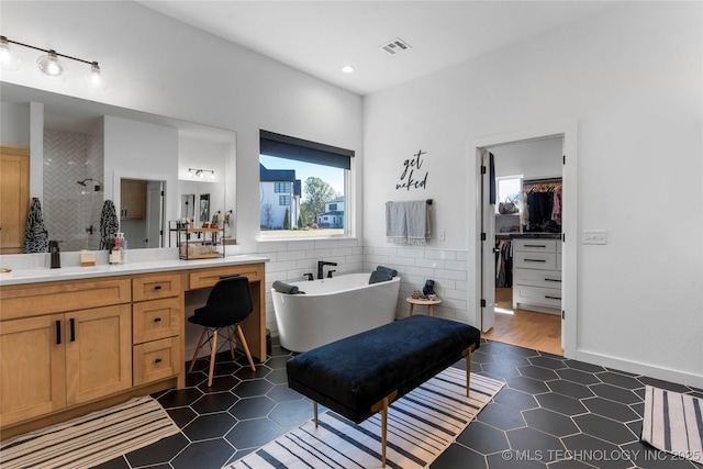 bathroom with tile patterned flooring, vanity, tile walls, and independent shower and bath