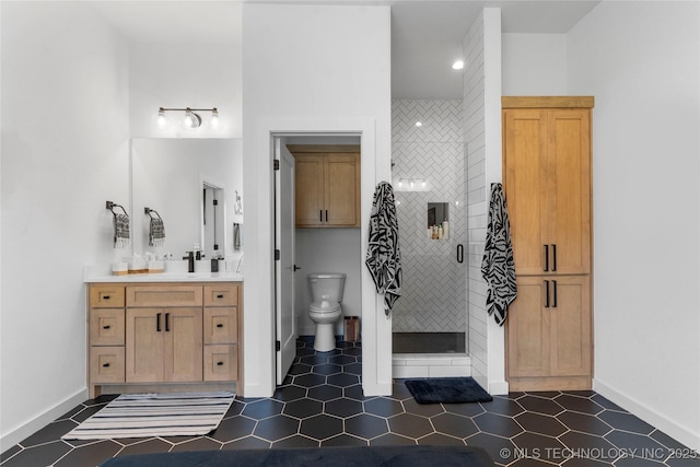 bathroom featuring tile patterned floors, vanity, a tile shower, and toilet