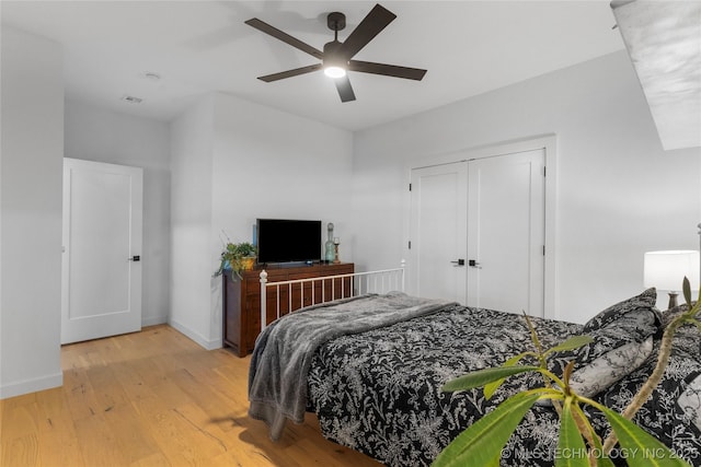 bedroom featuring ceiling fan, a closet, and light hardwood / wood-style floors