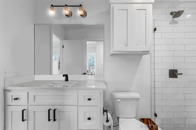 bathroom featuring vanity, toilet, and a tile shower