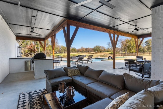 view of patio with outdoor lounge area, ceiling fan, and exterior kitchen