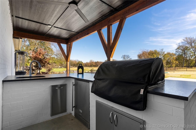 view of patio / terrace with a grill, a water view, and a wet bar