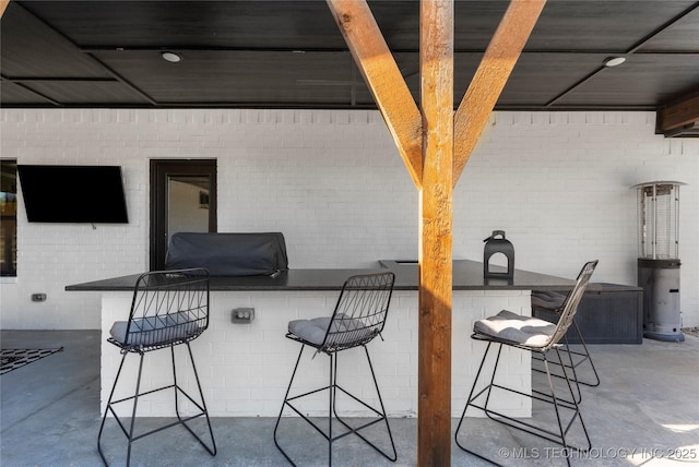 view of patio featuring an outdoor kitchen, a grill, exterior bar, and central AC