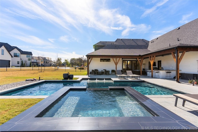 view of pool featuring a lawn, area for grilling, an in ground hot tub, a bar, and a patio