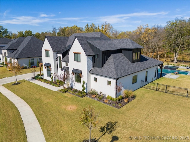 view of front of home with a fenced in pool and a front lawn