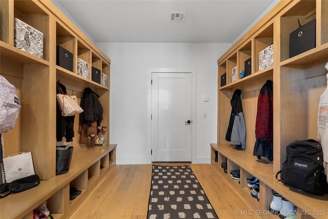 mudroom with baseboards, visible vents, and light wood finished floors