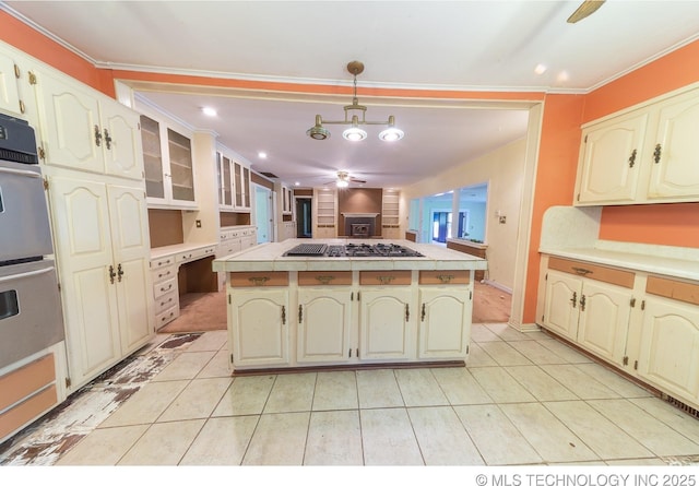 kitchen featuring ceiling fan, pendant lighting, a kitchen island, and stainless steel appliances