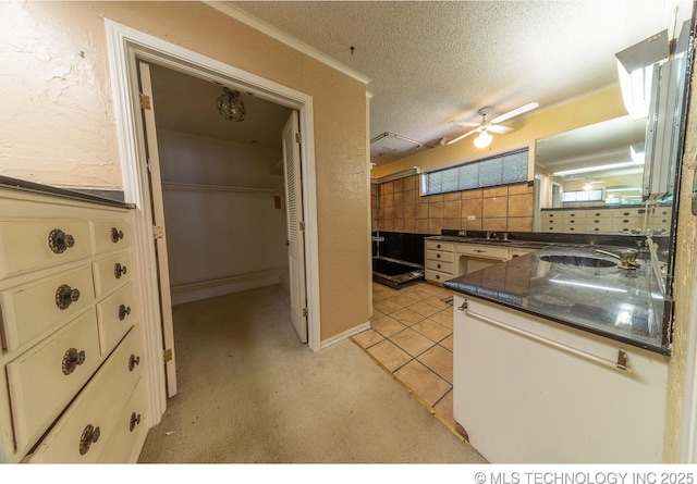 kitchen with white cabinetry, light tile patterned floors, ceiling fan, and a textured ceiling