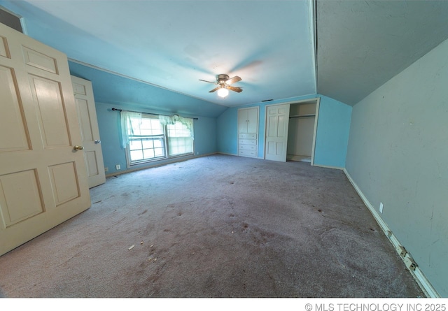 unfurnished bedroom featuring ceiling fan, light colored carpet, and vaulted ceiling