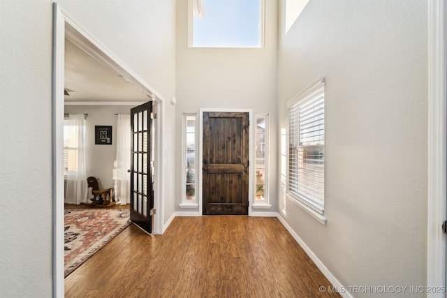 foyer entrance featuring hardwood / wood-style floors and crown molding