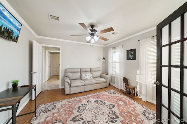 living room with ceiling fan, crown molding, and light hardwood / wood-style flooring