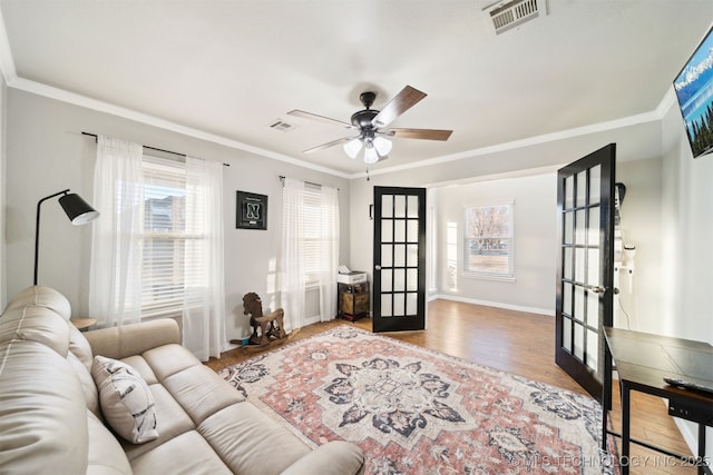 living room with ceiling fan, french doors, ornamental molding, and hardwood / wood-style flooring