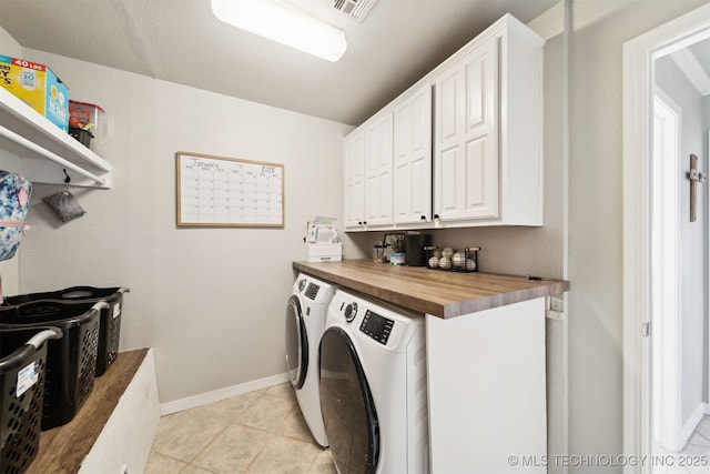 laundry room with separate washer and dryer, light tile patterned flooring, and cabinets