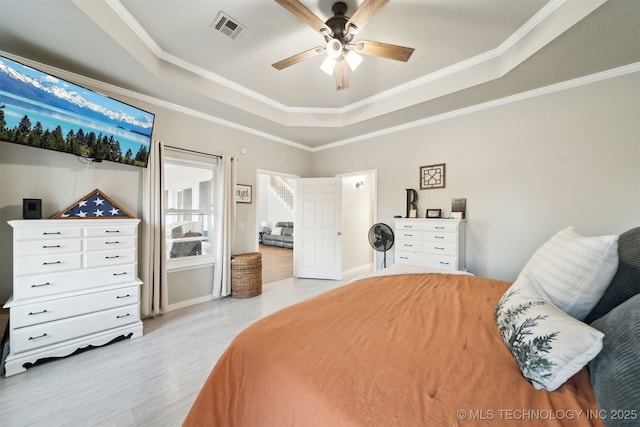 bedroom with a tray ceiling, ceiling fan, and crown molding