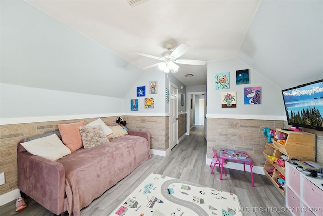 living room with ceiling fan, light hardwood / wood-style floors, and lofted ceiling