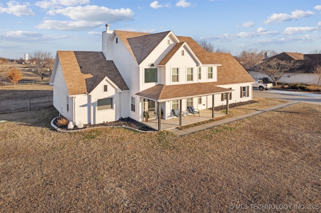 back of house with a patio area and a yard