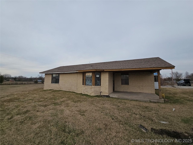 rear view of property featuring a patio area and a yard