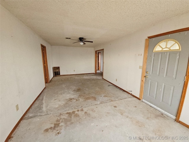 foyer entrance with ceiling fan and a textured ceiling