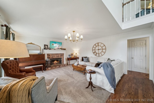 living room with a fireplace, dark hardwood / wood-style flooring, an inviting chandelier, and ornamental molding