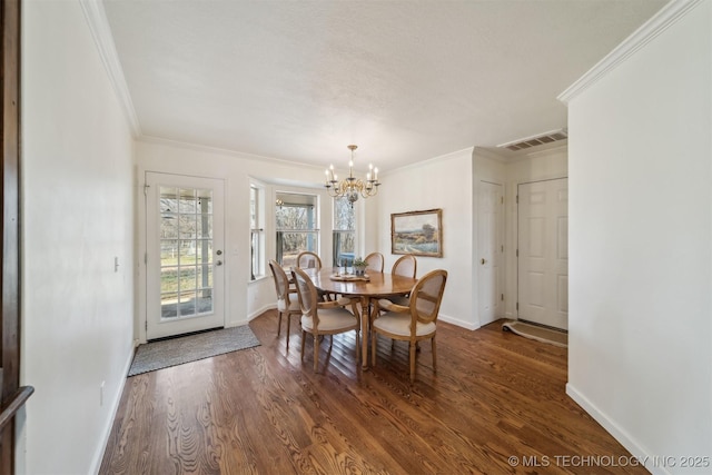 dining room with a chandelier, dark hardwood / wood-style floors, and crown molding