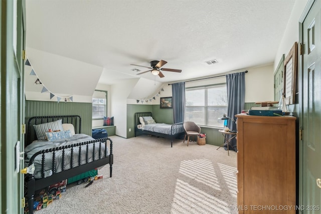 carpeted bedroom featuring vaulted ceiling, ceiling fan, and a textured ceiling