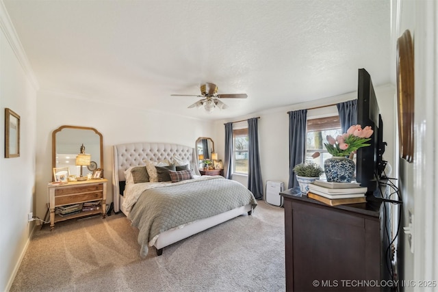 bedroom featuring carpet, a textured ceiling, ceiling fan, and ornamental molding