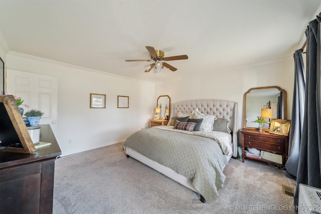 carpeted bedroom with ceiling fan and ornamental molding