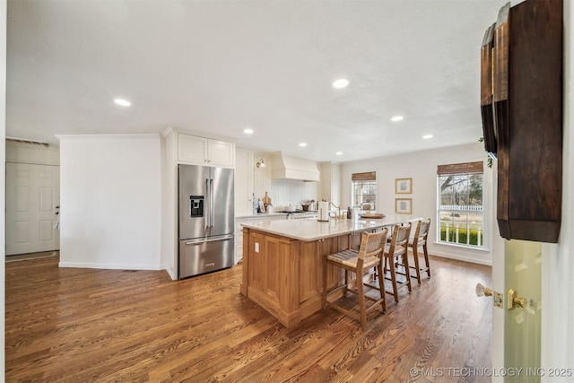 11818 N Harvard Ave, Skiatook, OK 74070 - kitchen featuring high end fridge, custom range hood, wood finished floors, light countertops, and recessed lighting