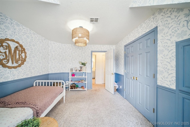 11818 N Harvard Ave, Skiatook, OK 74070 - carpeted bedroom with wallpapered walls, a wainscoted wall, and a closet