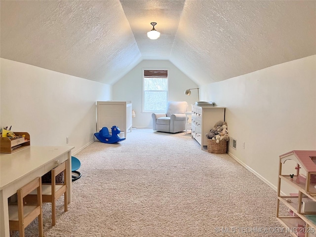 recreation room featuring carpet flooring, a textured ceiling, and vaulted ceiling