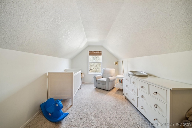 bedroom featuring a textured ceiling, light colored carpet, and vaulted ceiling