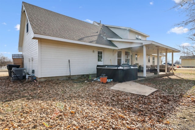 back of property with central AC unit and a patio area