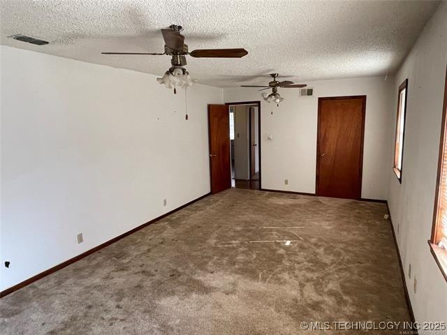 carpeted empty room with a textured ceiling and ceiling fan