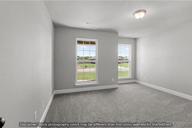 carpeted spare room featuring visible vents and baseboards