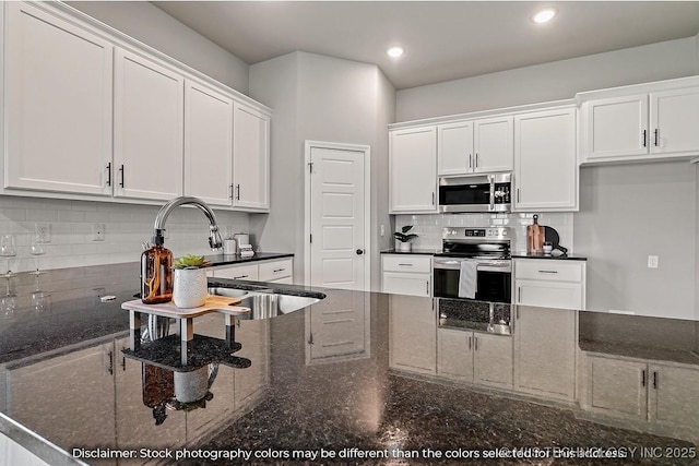 kitchen featuring white cabinets, decorative backsplash, appliances with stainless steel finishes, a sink, and recessed lighting