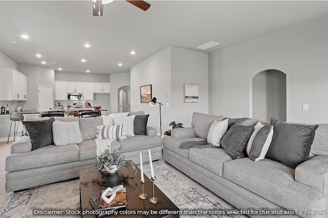 living area with visible vents, arched walkways, a ceiling fan, and recessed lighting